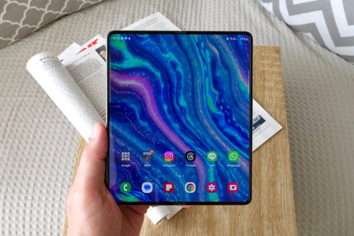 شخص يحمل هاتف Samsung Galaxy Z Fold 5 المفتوح، ويظهر الشاشة.