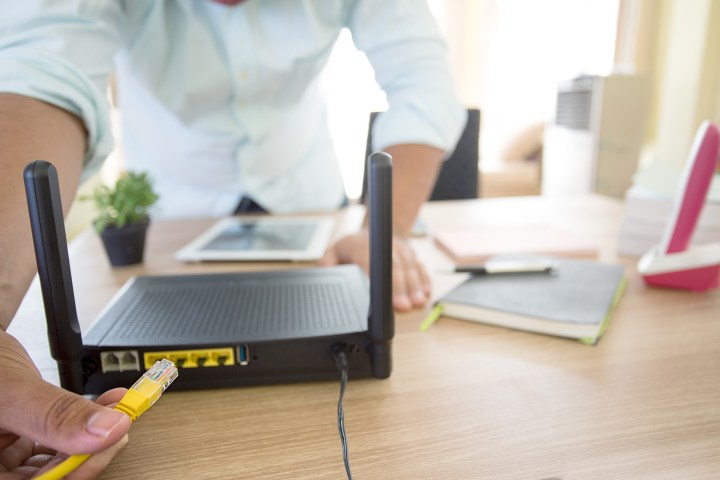 توصيل كابل Ethernet بالجزء الخلفي من جهاز توجيه Wi-Fi.