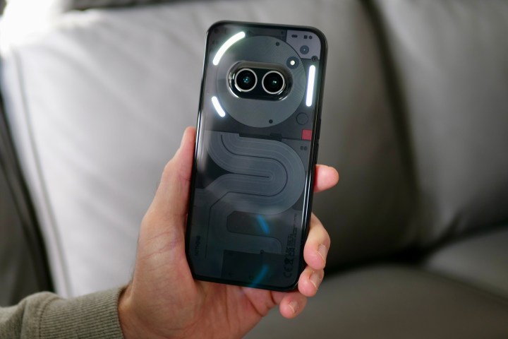 شخص يحمل هاتف Nothing Phone 2a، ويُظهر أضواء الحروف الرسومية.