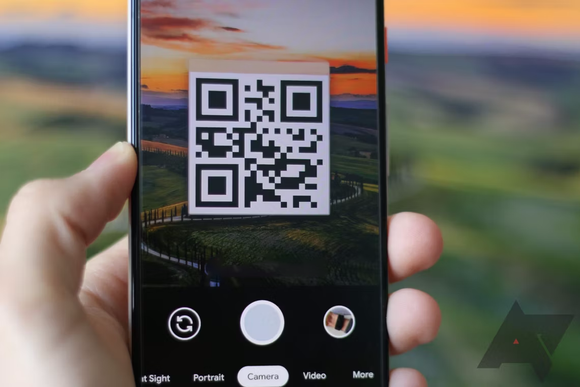 شخص يحمل هاتفًا به رمز QR على شاشته.