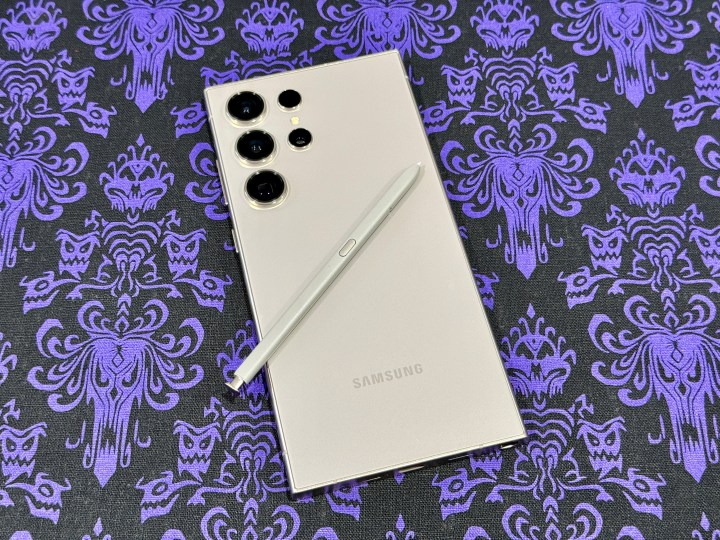 هاتف Samsung Galaxy S24 Ultra باللون الرمادي التيتانيوم مع قلم S Pen في الخلف.